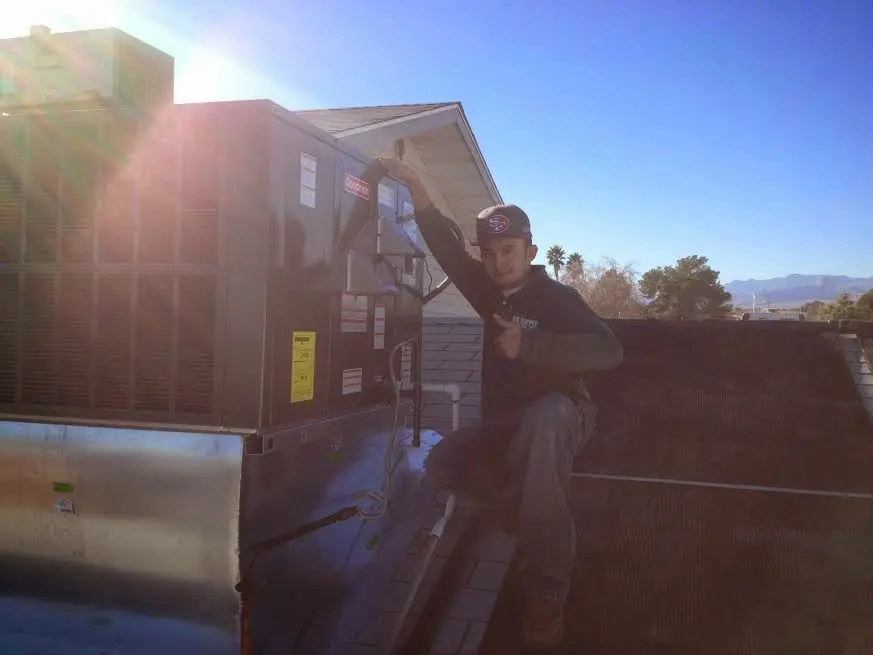 HVAC technician performing Air Duct Repair on a rooftop unit in Milwaukie